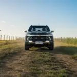 imagem mostra uma Chevrolet S10 em uma estrada de terra de uma fazenda. O veículo está vindo em direção à câmera.
