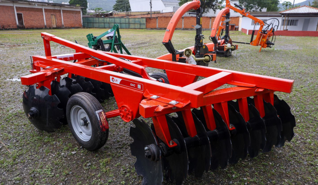 A imagem registra a entrega de equipamentos agrícolas em Santa Catarina