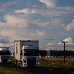 Caminhão transportando grãos em rodovia brasileira, representando a dependência do modal rodoviário na logística