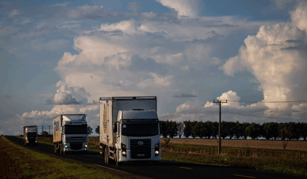 Caminhão transportando grãos em rodovia brasileira, representando a dependência do modal rodoviário na logística