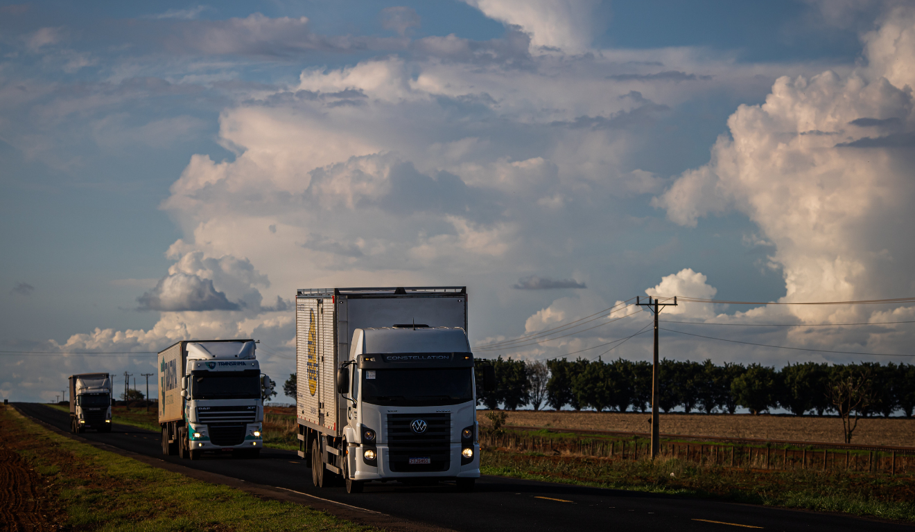 Caminhão transportando grãos em rodovia brasileira, representando a dependência do modal rodoviário na logística Caminhão transportando grãos em rodovia brasileira, representando a dependência do modal rodoviário na logística